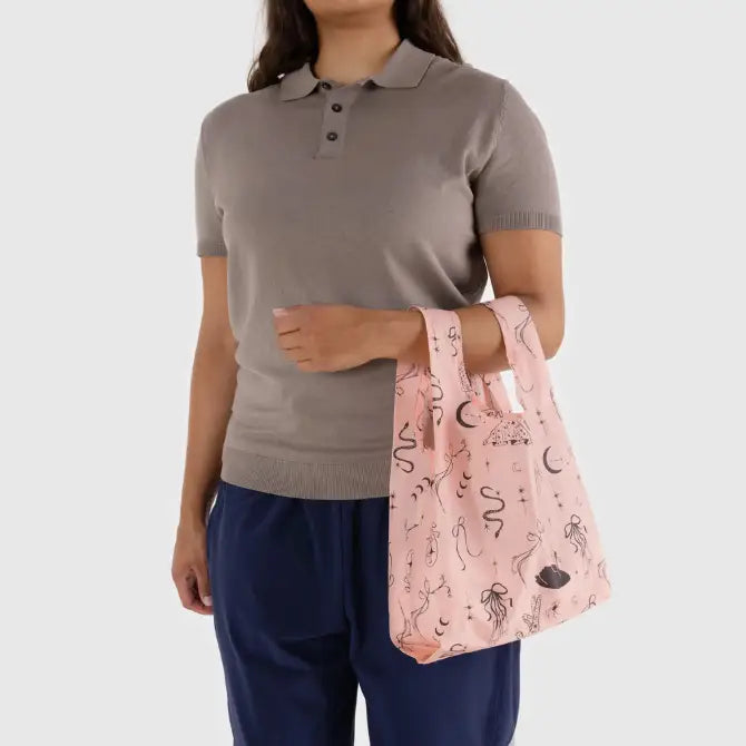Pink baby Baggu featuring a pattern of drawings being held on the arm - PABOOM