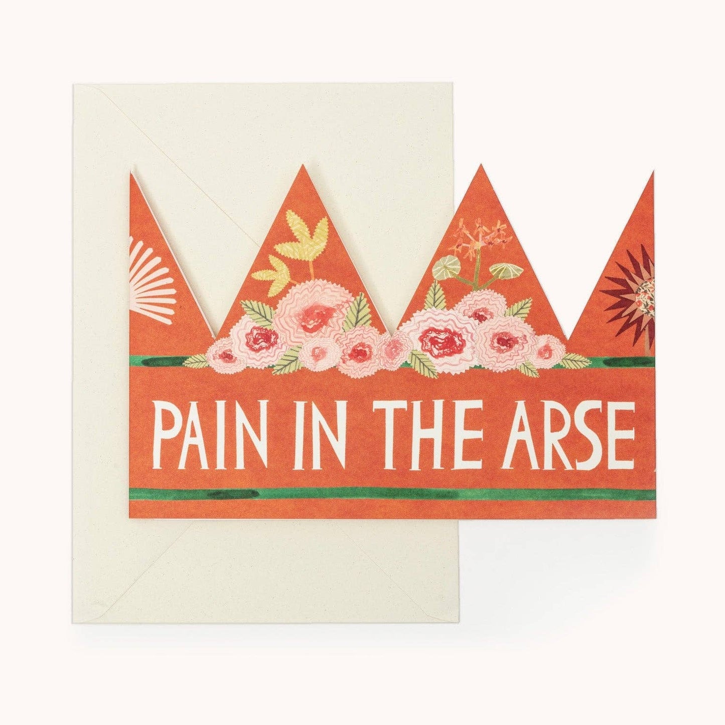 Orange party hat crown card with a pink floral band and the words 'PAIN IN THE ARSE' in white, with a cream envelope behind
