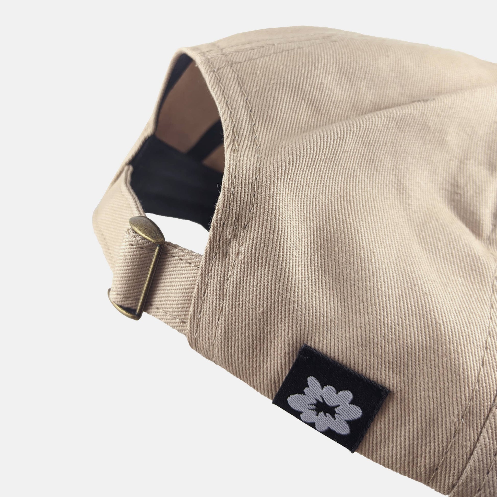 Side view of The Triplets tan dad hat showing adjustable metal clasp - PABOOM