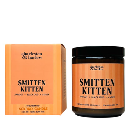 Charleston & Harlow Smitten Kitten soy candle in amber glass jar with peach striped label, beside its matching gift box