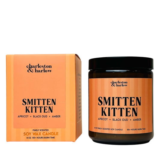 Charleston & Harlow Smitten Kitten soy candle in amber glass jar with peach striped label, beside its matching gift box