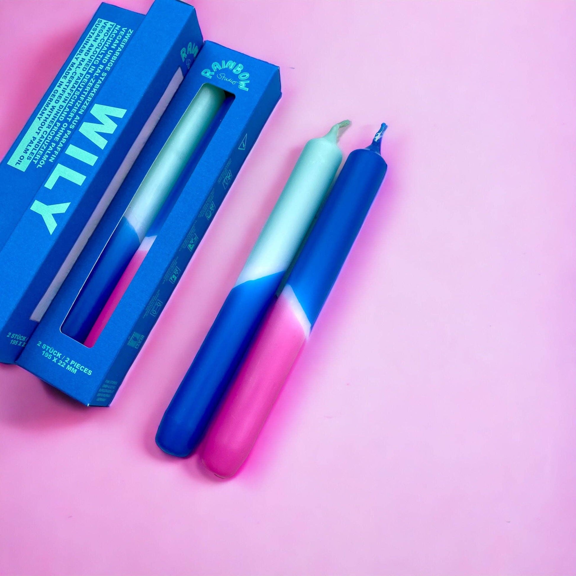 Rainbow Studio Dinner Candle Set Wily — two dip-dyed taper candles in mint-blue and blue-to-pink gradients, shown with blue packaging