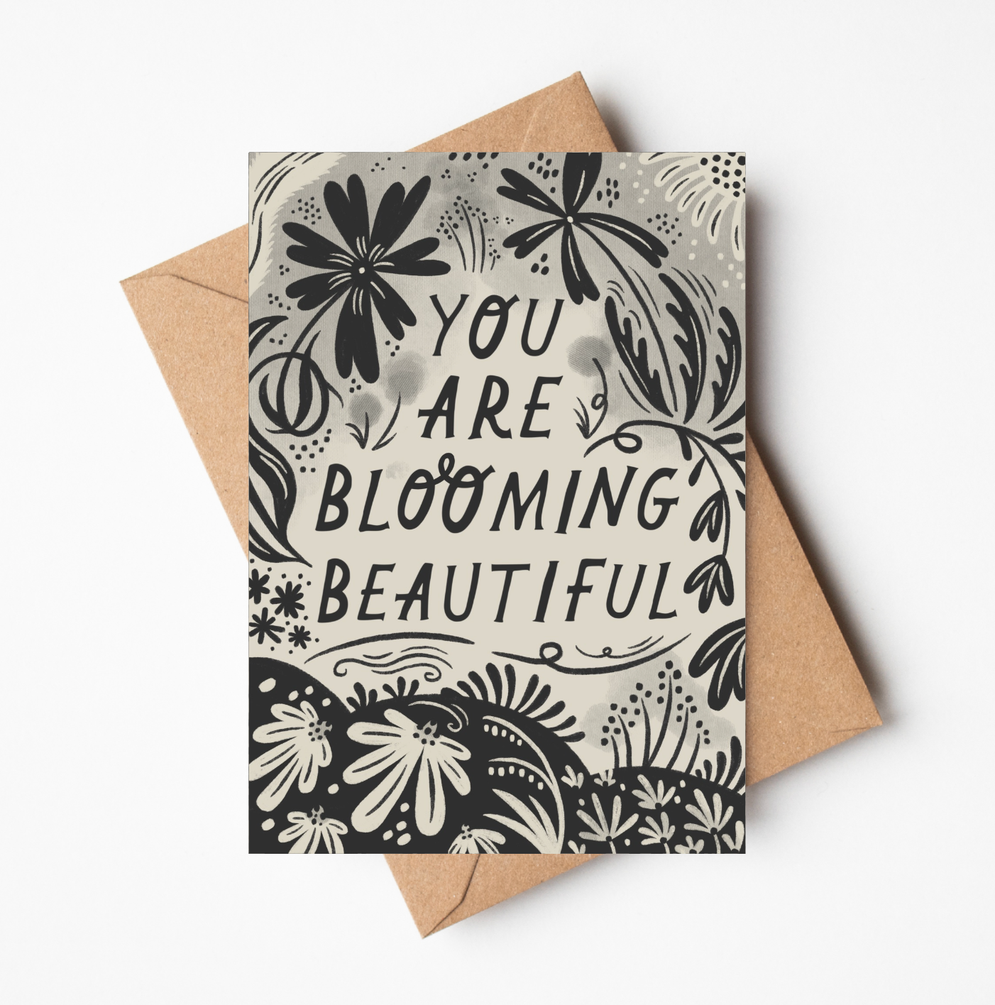 'You Are Blooming Beautiful' card featuring bold black botanical illustration and hand-lettered text on a cream background