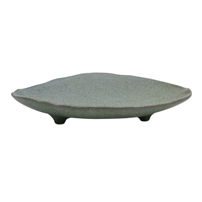 Speckled sage green porcelain plate with a leaf-like oval silhouette, standing on three small tripod feet