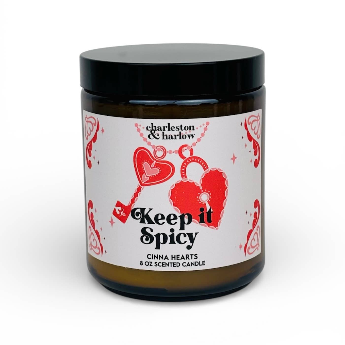 Charleston & Harlow Keep It Spicy soy candle in amber glass jar with white label featuring red heart lock and key illustration
