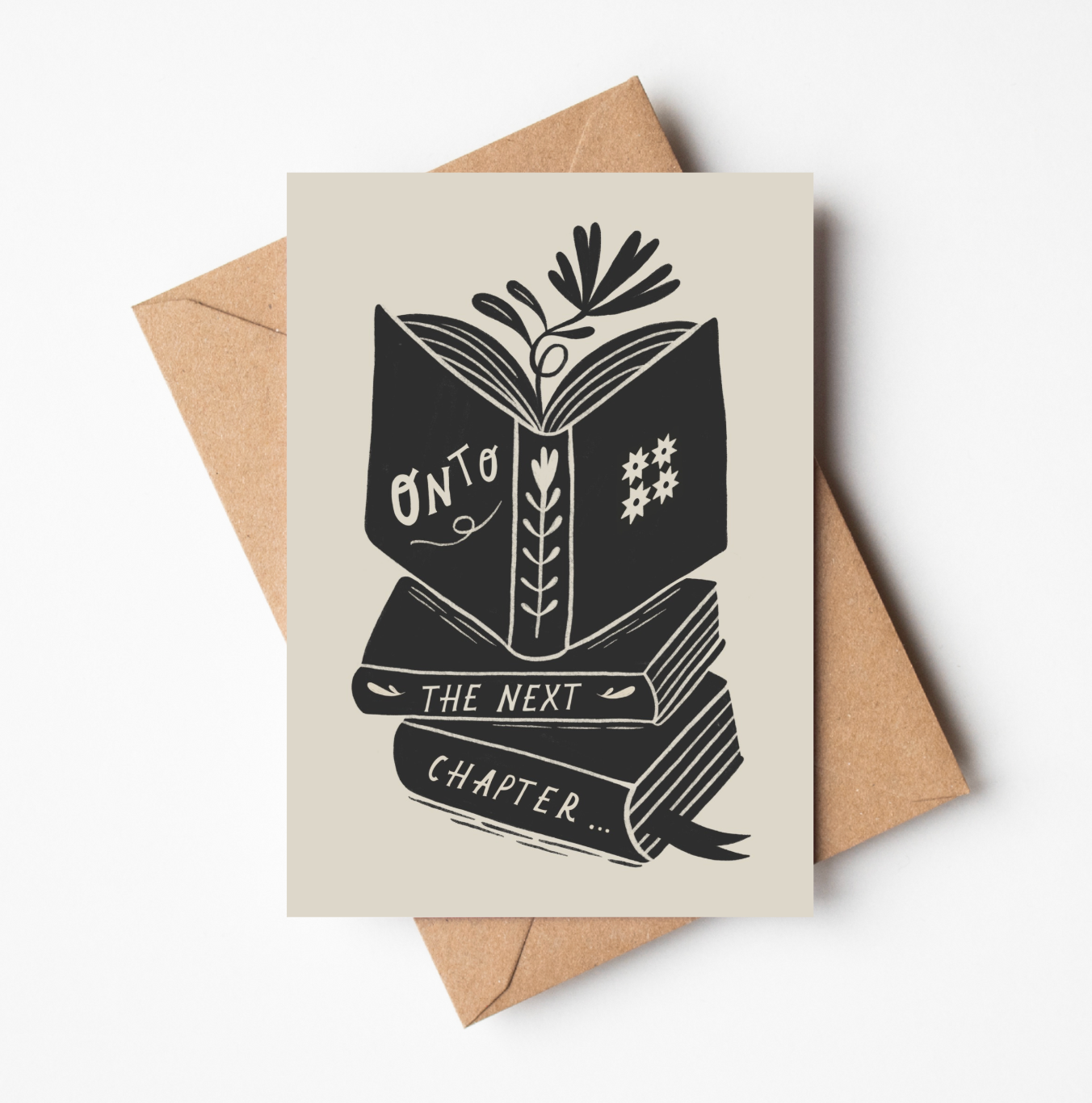 'Onto The Next Chapter...' card featuring a bold black illustration of an open book atop a stack of books, with botanical details, on a cream background