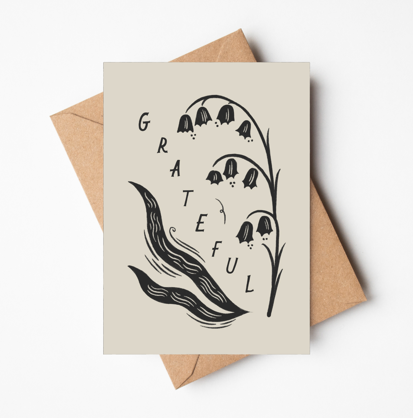 'Grateful' gratitude card with black and white botanical illustration of lily of the valley flowers and the word GRATEFUL in bold lettering, on a cream card