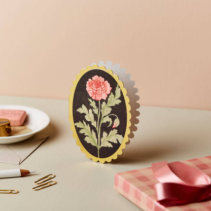 Pink rose illustration on black background, oval mini card with gold scalloped edge