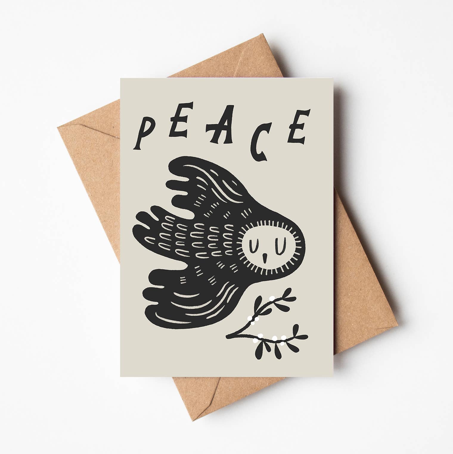 'Peace' Christmas card featuring a black illustrated owl in flight beneath the word 'PEACE', with a small sprig of berries, on a cream background