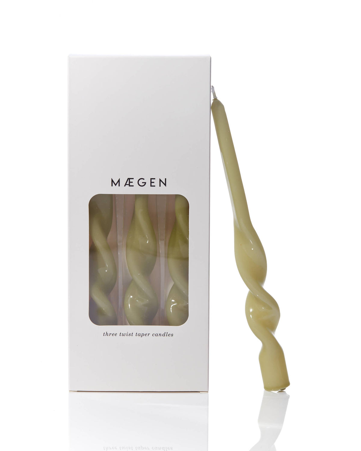 MÆGEN twist taper candle in glossy leaf green leaning against its white branded box printed "three twist taper candles"