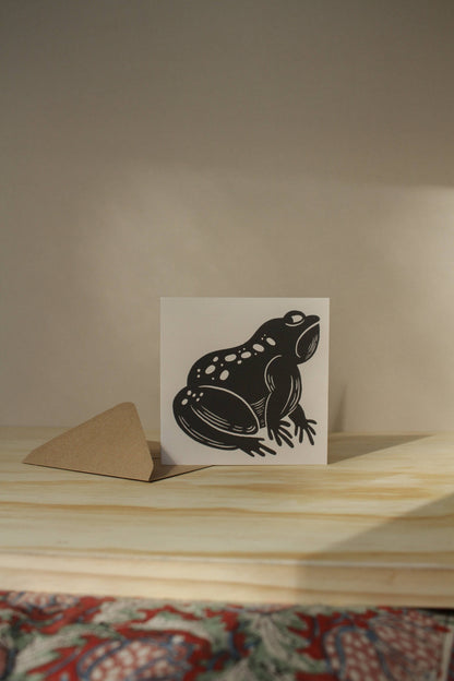 'The Grumpy Frog' card laid flat beside its kraft envelope on a light background