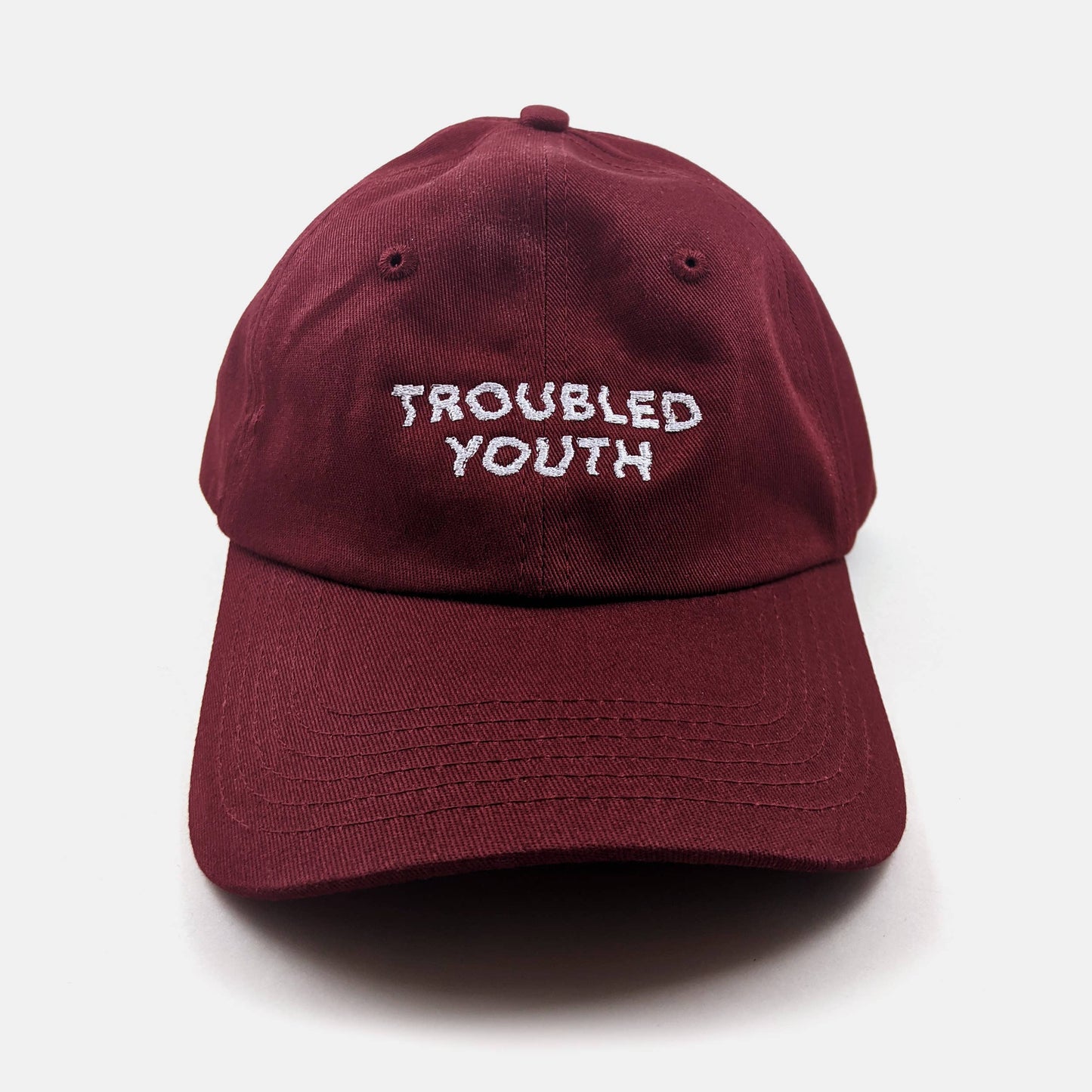 Burgundy unstructured dad hat embroidered with the words Troubled Youth - PABOOM