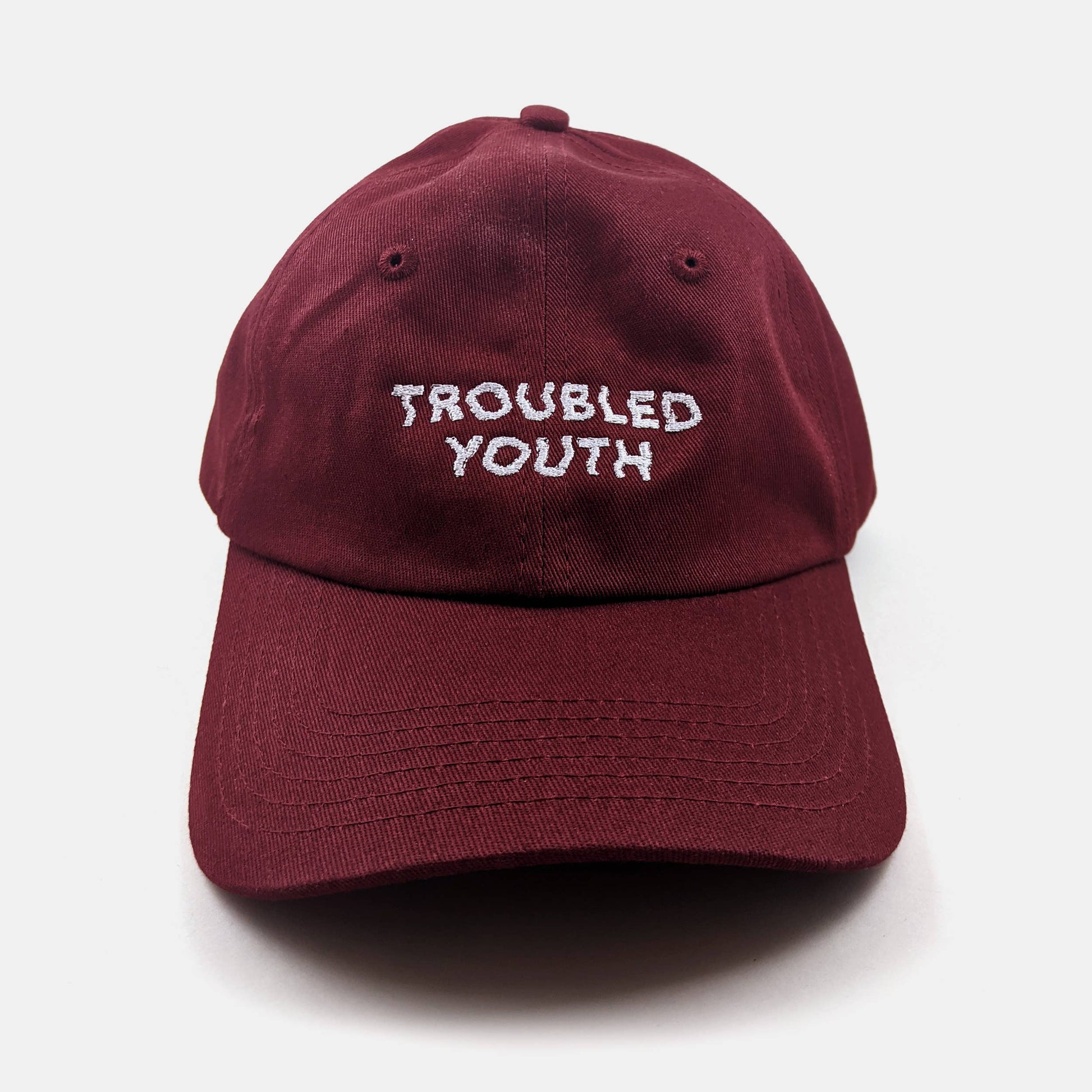 Burgundy unstructured dad hat embroidered with the words Troubled Youth - PABOOM
