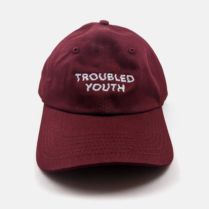 Burgundy unstructured dad hat embroidered with the words Troubled Youth - PABOOM