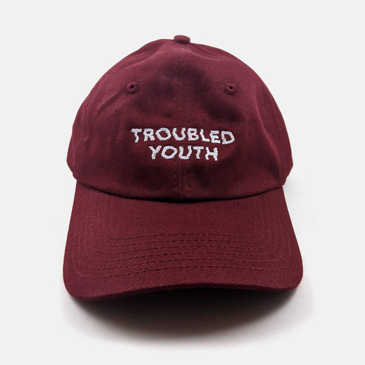 Burgundy unstructured dad hat embroidered with the words Troubled Youth - PABOOM