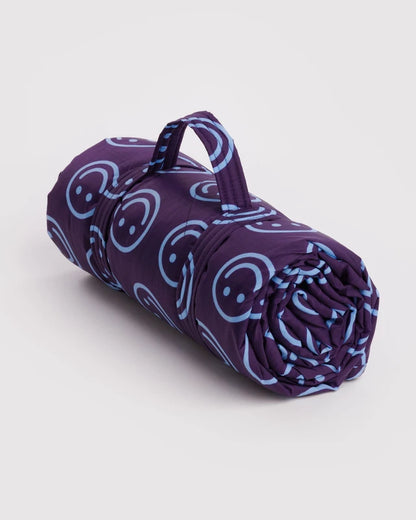 BAGGU Puffy Picnic Blanket in indigo happy smiley print rolled with carrying strap - PABOOM