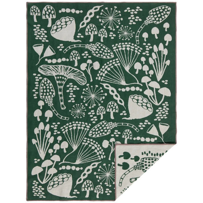 Forest green cotton dishtowel with a cream mushroom and botanical print, folded to show a mirrored reverse panel – PABOOM