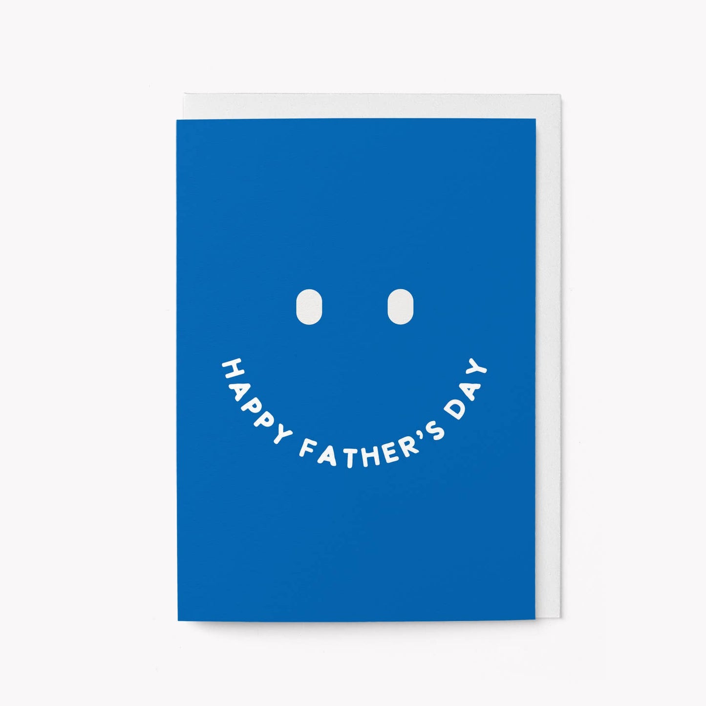 Bold blue greeting card with a large minimalist smiley face, the mouth formed by the words 'HAPPY FATHER'S DAY'
