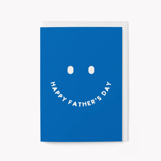 Bold blue greeting card with a large minimalist smiley face, the mouth formed by the words 'HAPPY FATHER'S DAY'