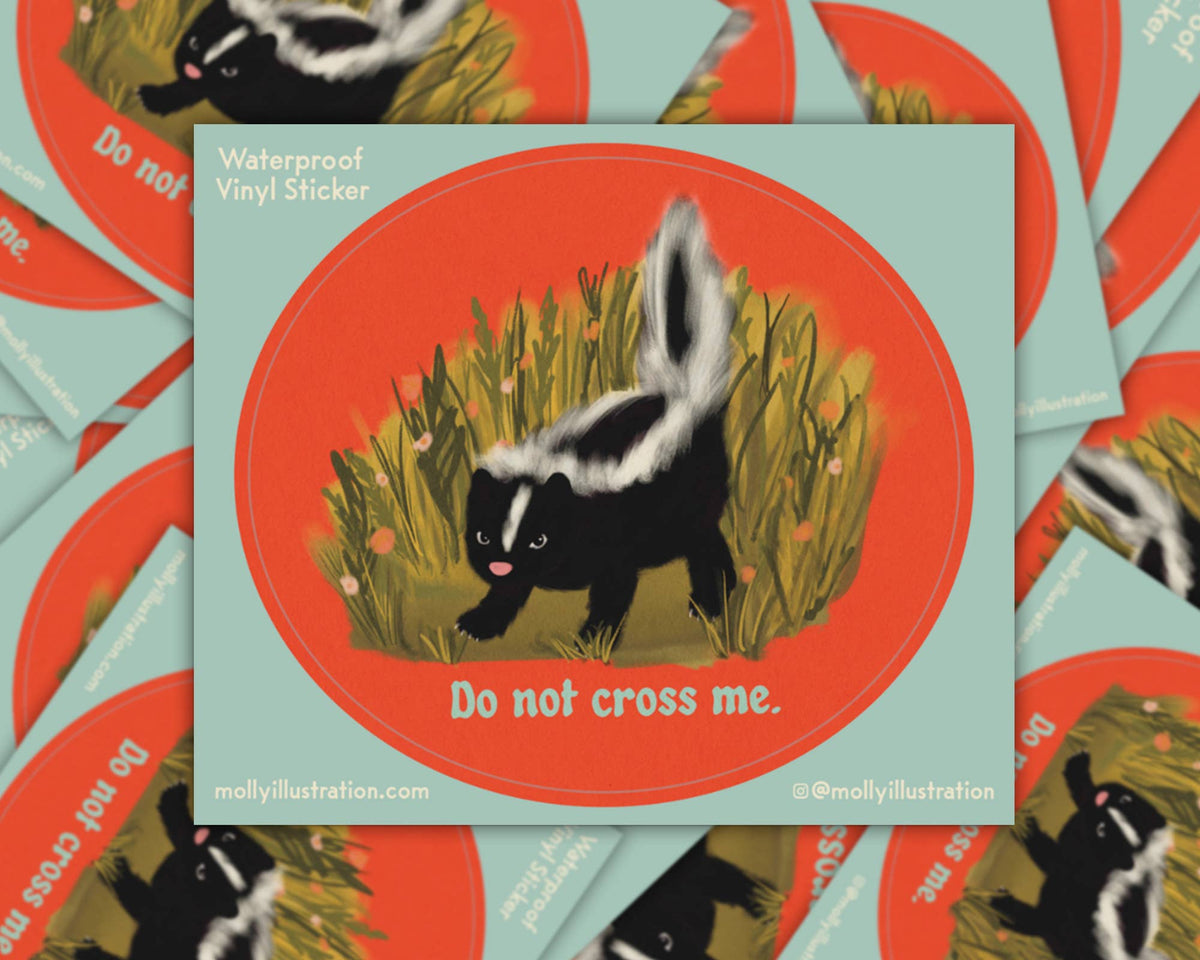 Matte vinyl sticker of a skunk standing in grass inside a teal circle badge on an orange background, with the text 'Do Not Cross Me'