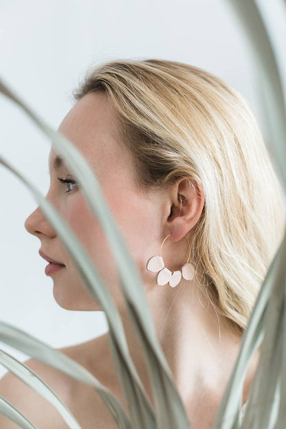 Close-up of blush pink leather petal hoop earring detail