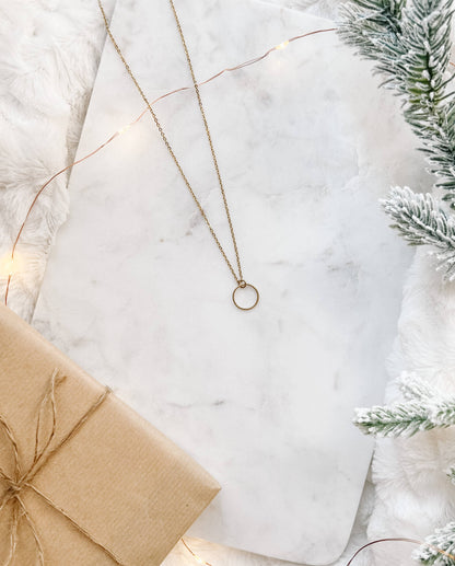 Raw brass circle pendant necklace styled flat lay