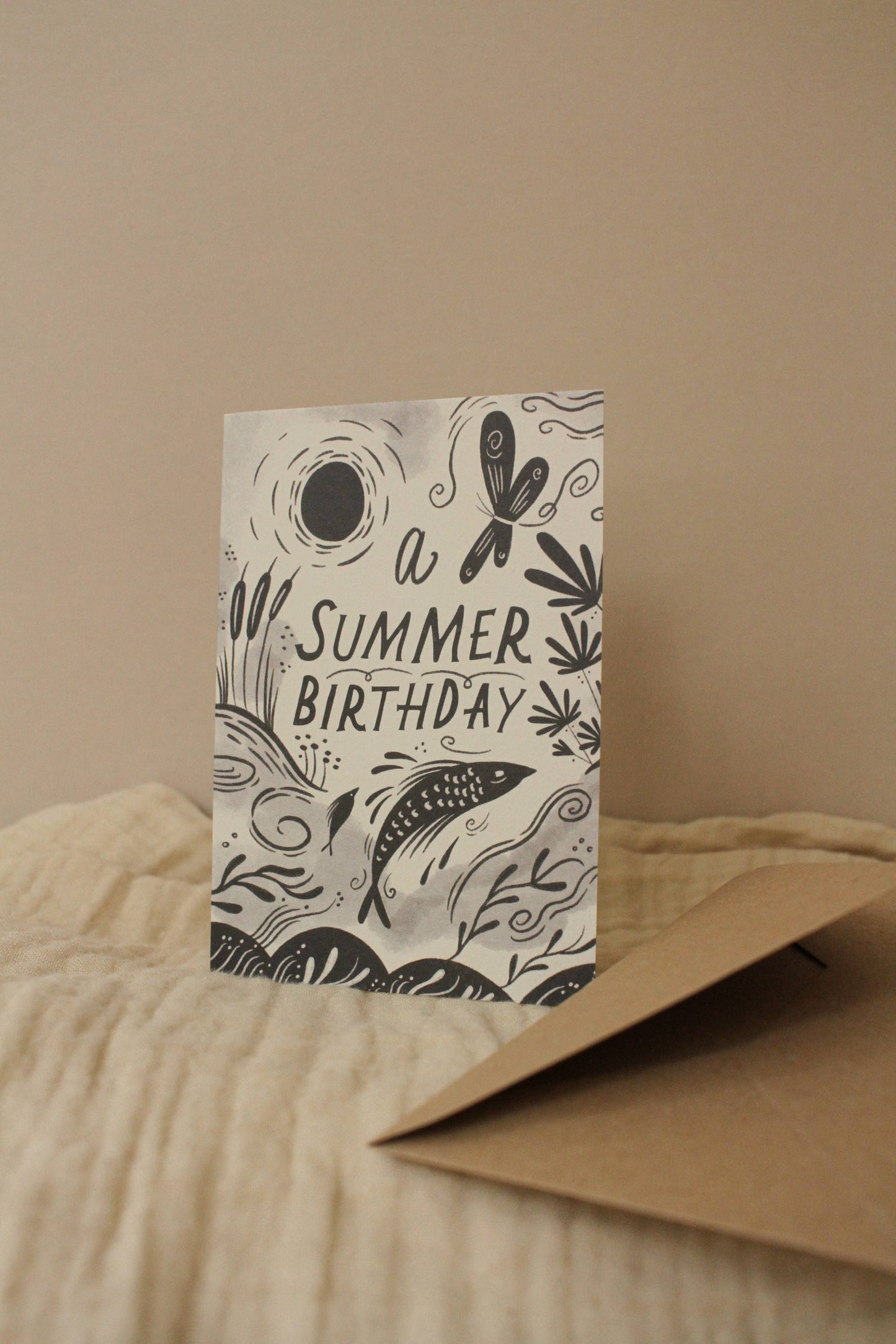 'A Summer Birthday' card with kraft envelope on a light background