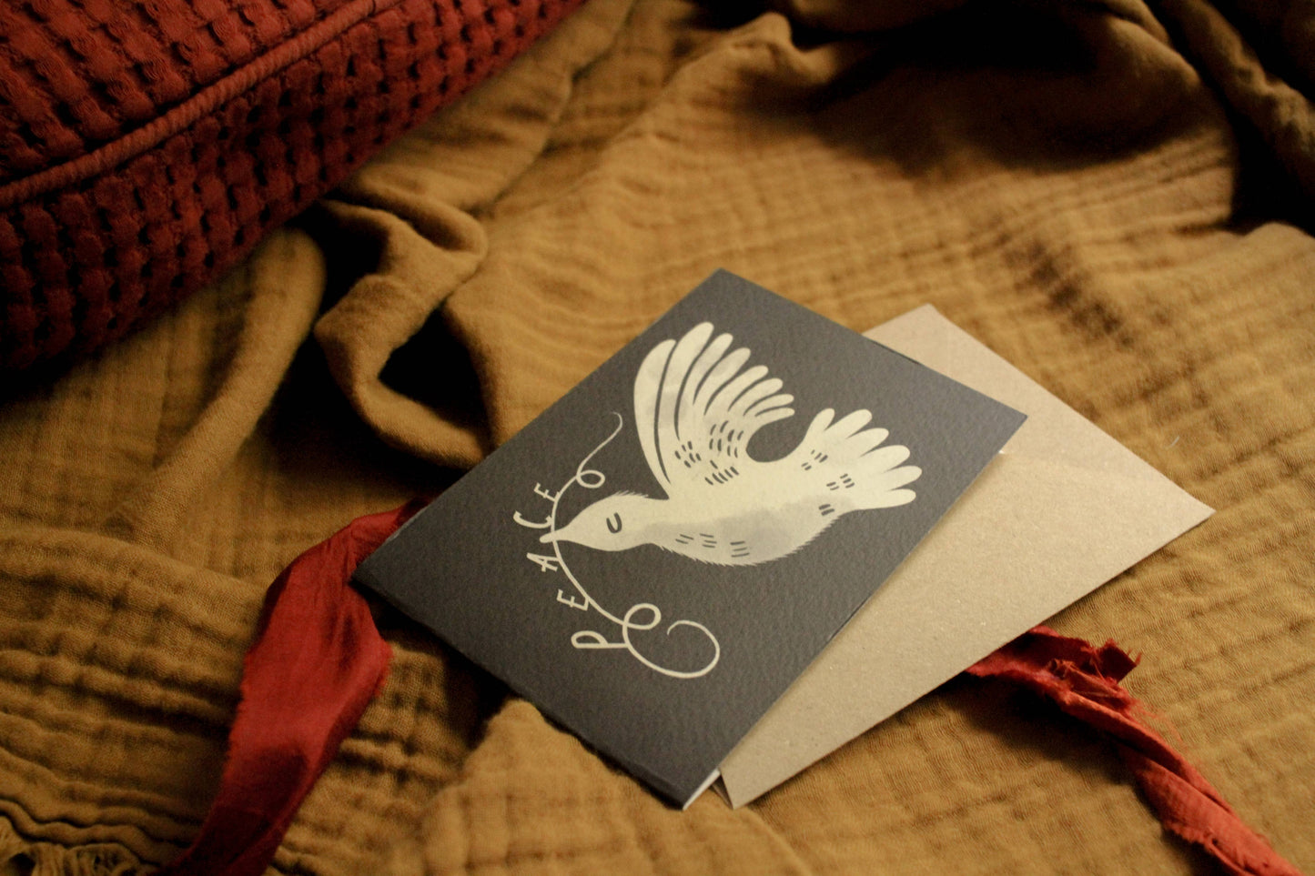 'A Dove for Peace' card with kraft envelope, shown at an angle on a light backdrop