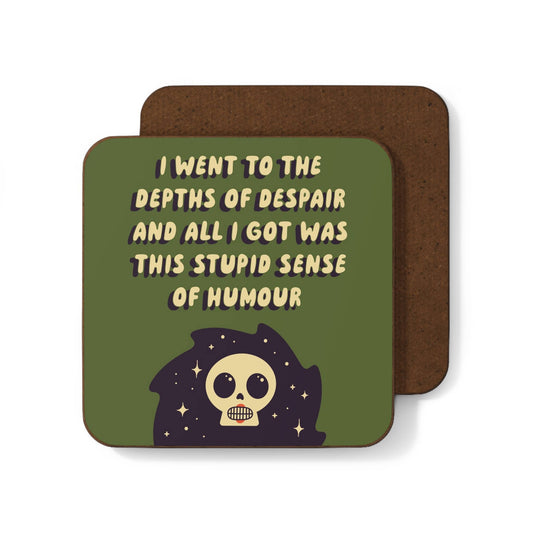 Olive green coaster with cream text "I went to the depths of despair and all I got was this stupid sense of humour" above an illustrated grinning skull surrounded by stars