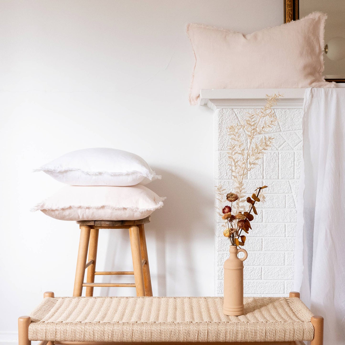 Blush fringed linen lumbar pillow cover styled on a sofa or bed