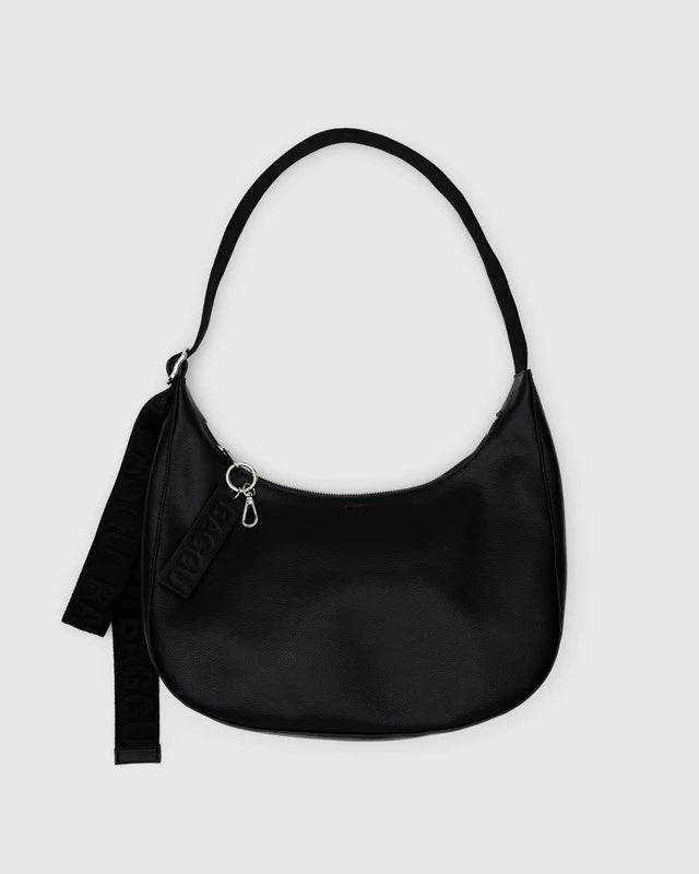 Black BAGGU Medium Recycled Leather Flat Crescent bag with a single adjustable strap, shown against a light grey background