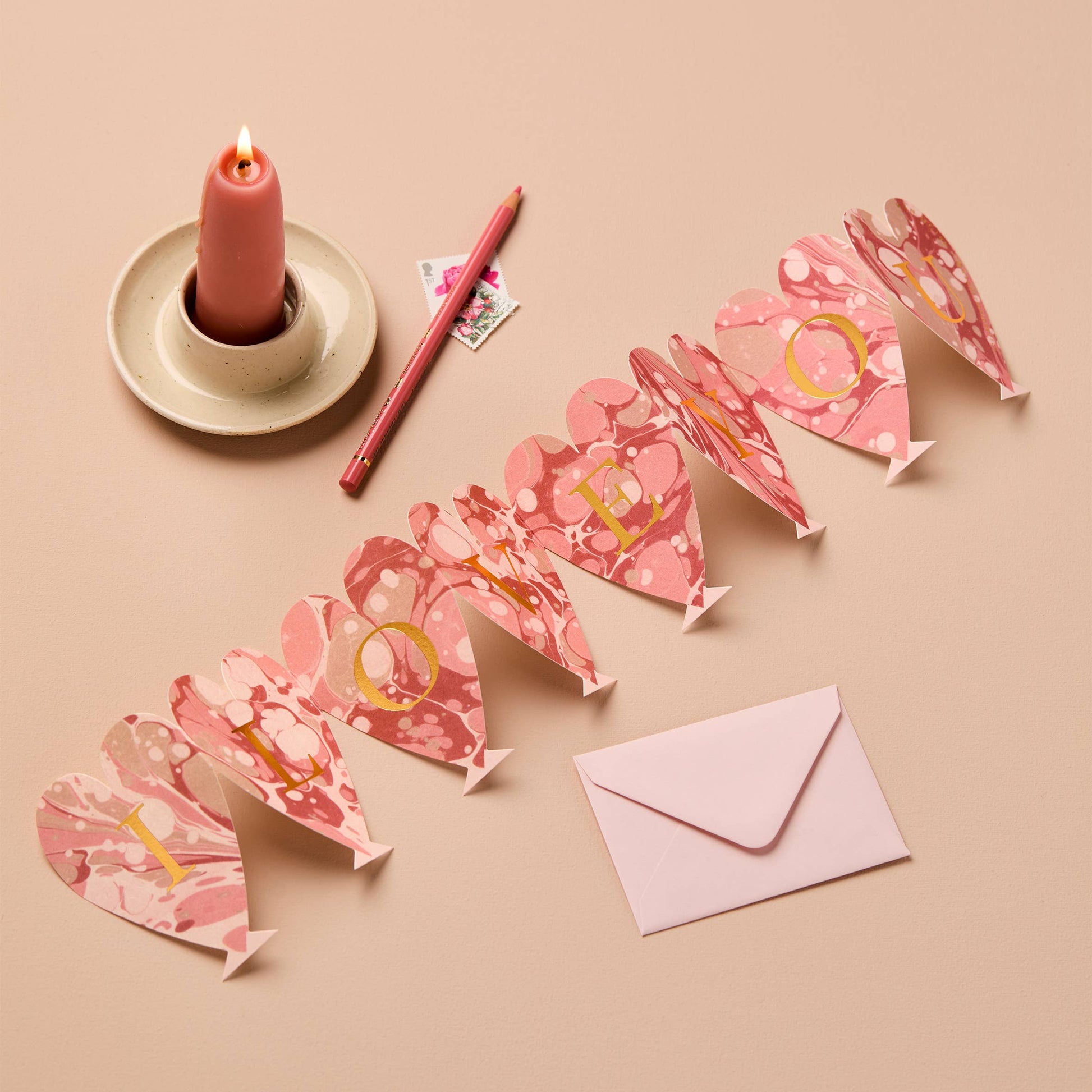 Pink marbled heart-shaped concertina card spelling I LOVE YOU in gold letters
