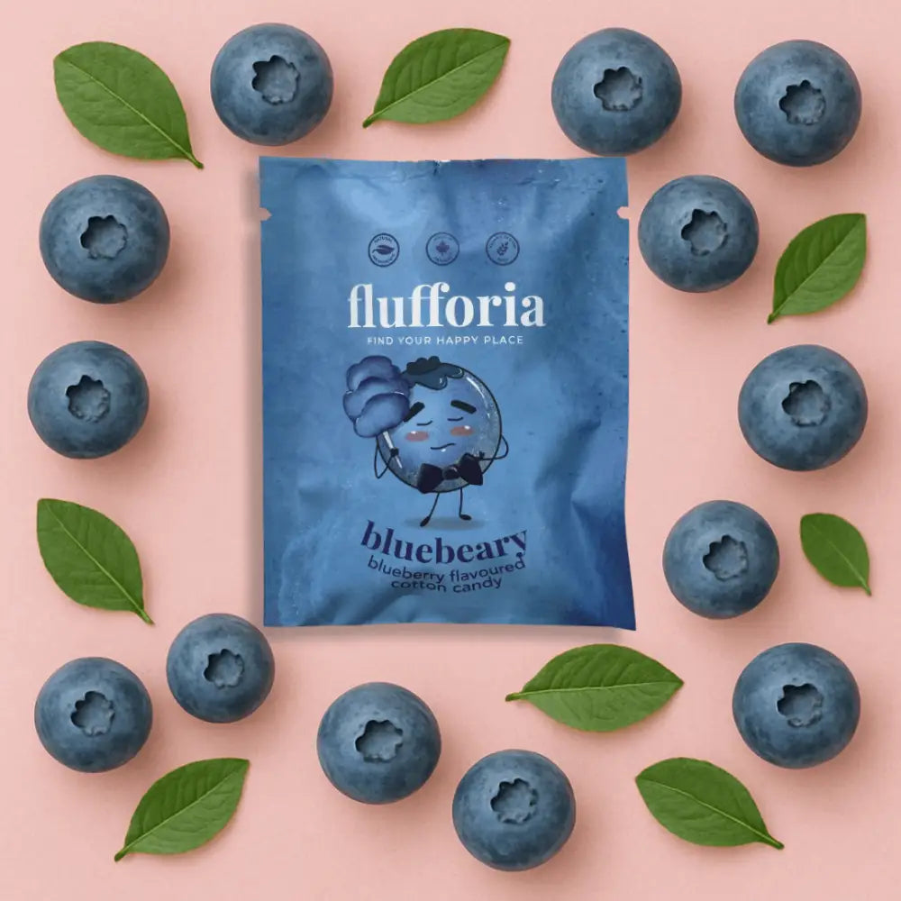 Package of Flufforia’s cotton candy, bluebeary flavour, blue package, pink background with blueberries - PABOOM