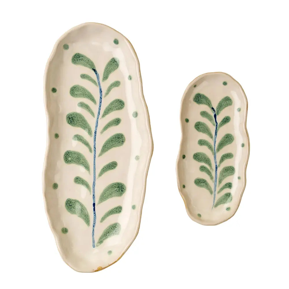 Two ceramic trays with leaf patterns on a beige background