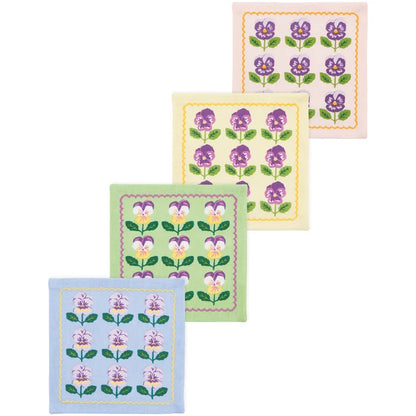Four square cotton cocktail napkins in pink, yellow, green, and blue, each printed with a grid of purple pansies – PABOOM