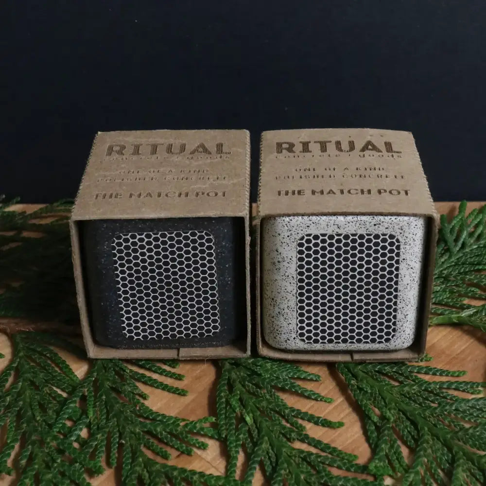 Packaged concrete match stick holder, one in black, one in white