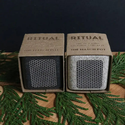 Packaged concrete match stick holder, one in black, one in white