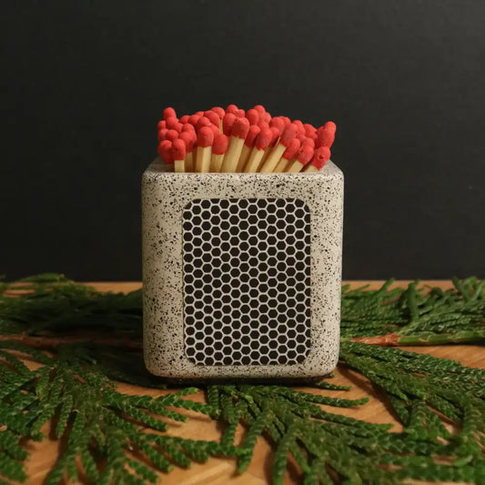 Concrete white cube match holder with strike pad on side, matches inside