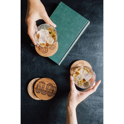 Close-up of the laser-engraved snake medallion on an Olympus acacia coaster - PABOOM