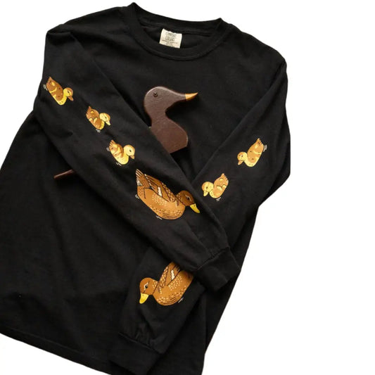 A mama duck and her brood of 3 fluffy ducklings follow the leader down the sleeves of this long sleeve tee. Black, cotton. - PABOOM