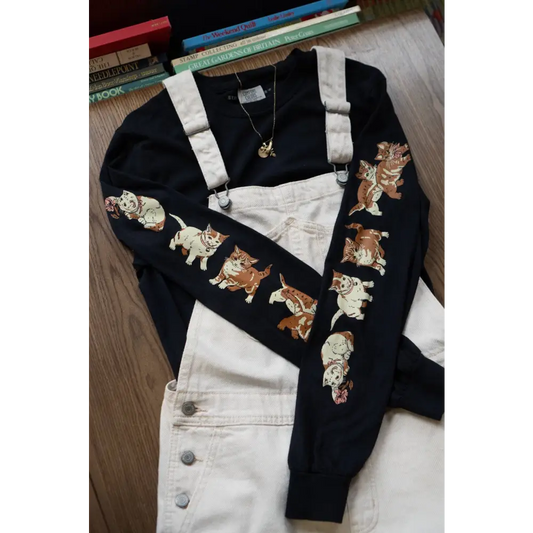 Black Cotton Long Sleeve t-shirt with images of kittens down each sleeve. Cotton, black. White overalls overtop -  PABOOM