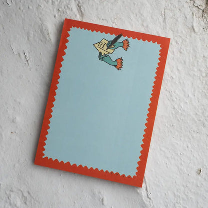 Notepad with a top logo of two hands writing a letter “SUP BABE”. Blue, with red squiggle outline, by Stay Home Club | PABOOM
