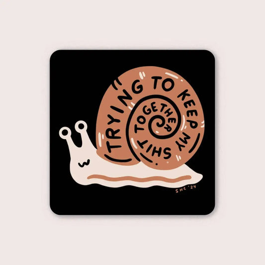 Black vinyl sticker with brown snail with text spiralling in shell “TRYING TO KEEP MY SHIT TOGETHER” by Stay Home Club - PABOOM