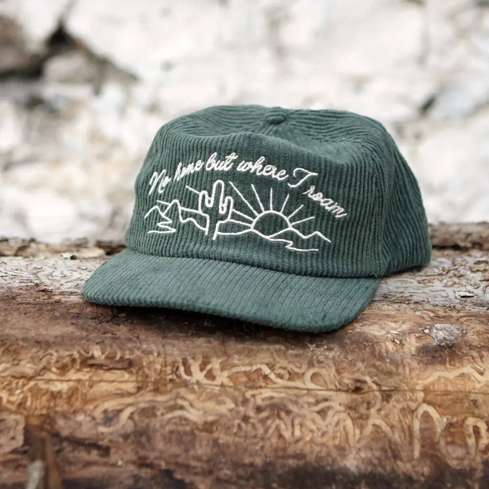 Sage green Corduroy hat with cream embroidered cactus and sunset with words “No home but where I roam” on wood log - PABOOM