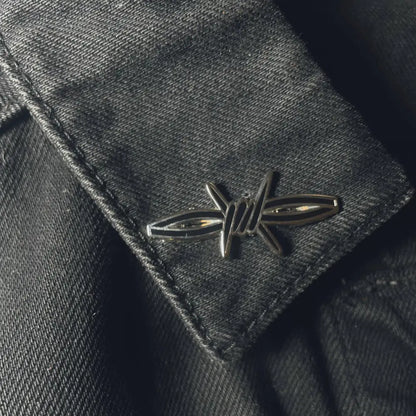 a section of barb wire shaped lapel pin on jacket collar