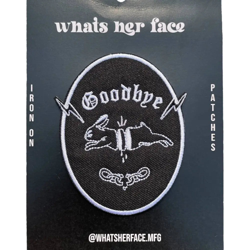 Iron on embroidered patch of a chopped-up rabbit jumping and "goodbye" written underneath. Black with white embroidery. Packaged