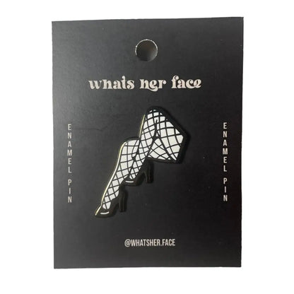 a black and silver lapel pin in the shape of a pair of legs wearing fish net tights and black high heels, on cardstock