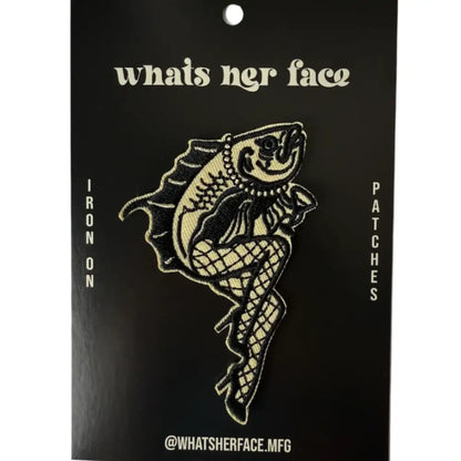 Iron on embroidered patch of a fish with legs wearing fishnets and heels and holding a martini, on cardstock