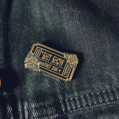 Enamel Pin shaped like a ticket with text Shit Show Admit One