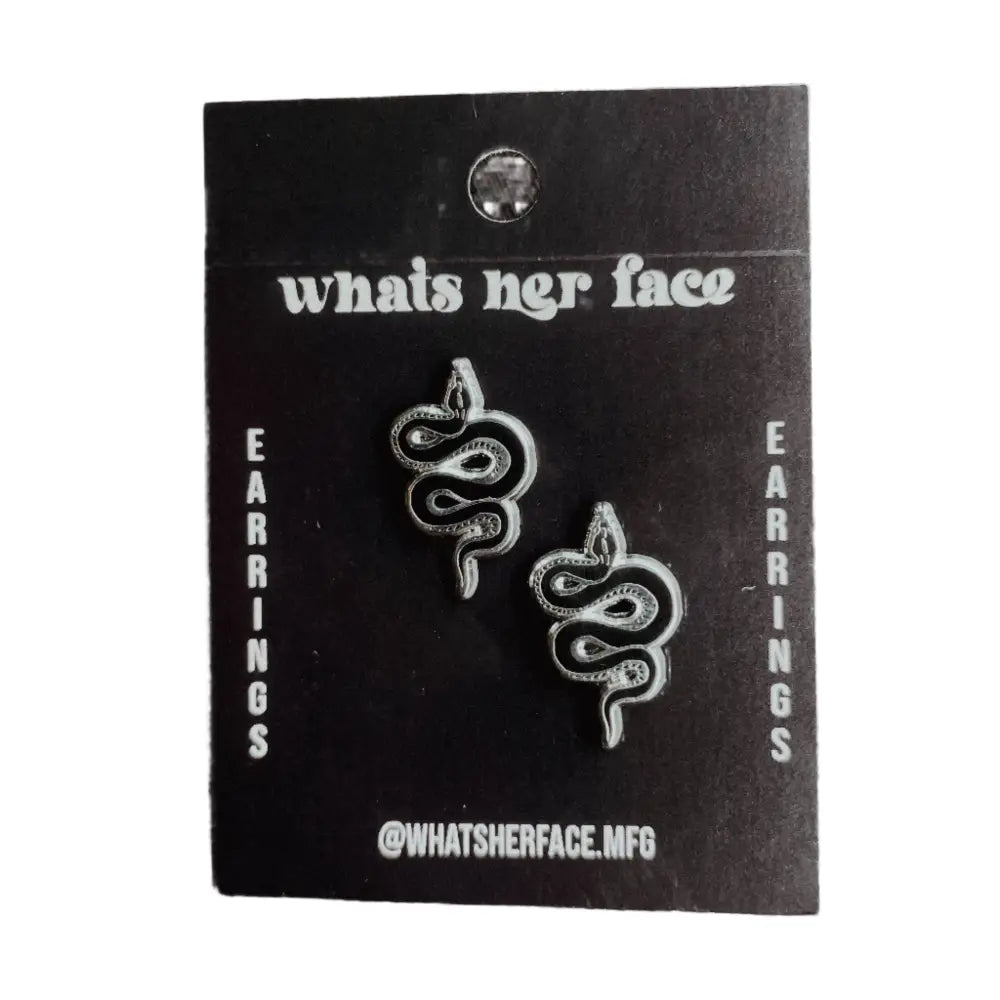 Tiny black and silver hard enamel snake earring studs on cardstock | PABOOM